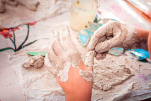Closeup of children's dirty hands in clay